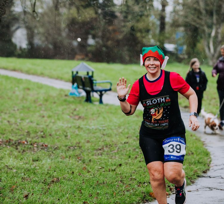 Woman smiling and waving during the run