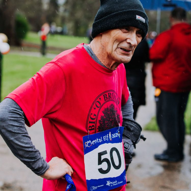 Man standing with hands on hips after finishing the run