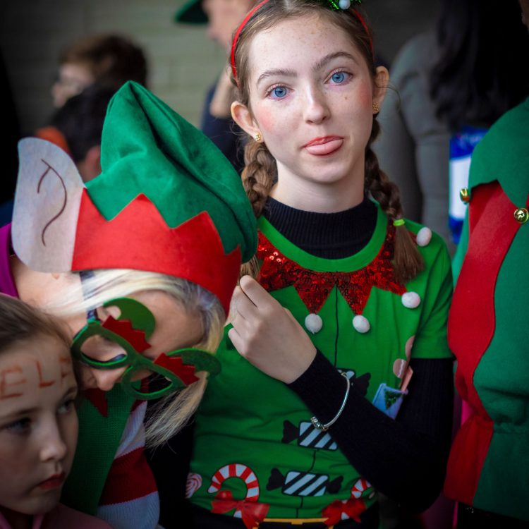Girl in elf costume poking her tongue out at the camera