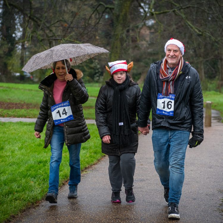 Three people wearing festive hats walking