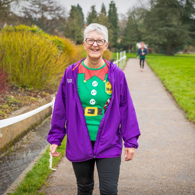 A woman standing still smiling at the camera