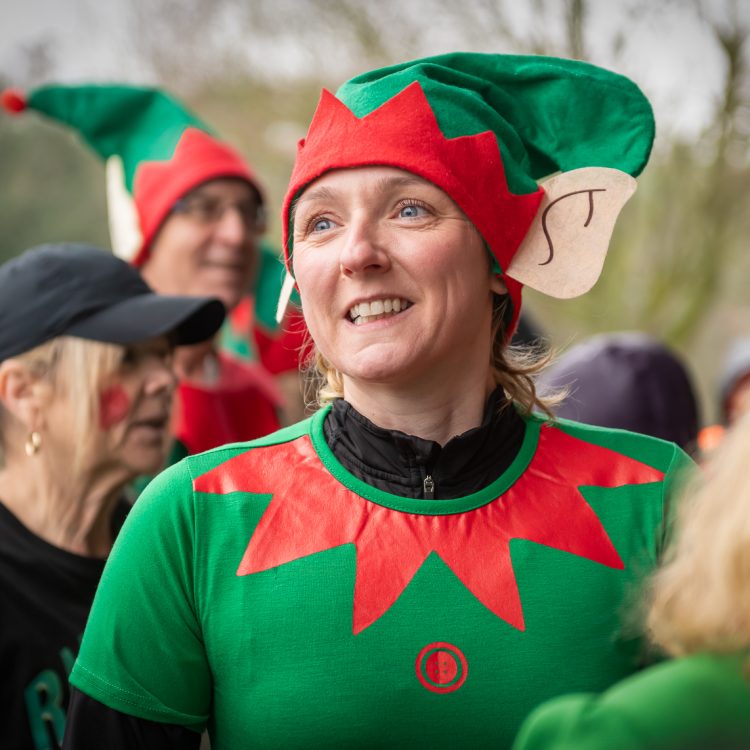 A close-up shot of a woman smiling in an elf outfit