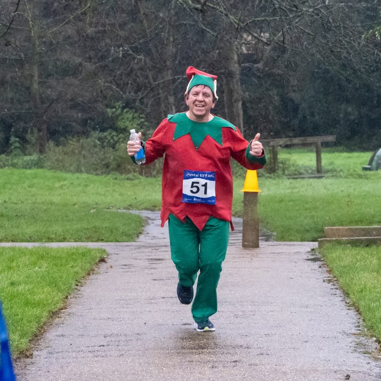 A man in elf costume giving two thumbs up to the camera