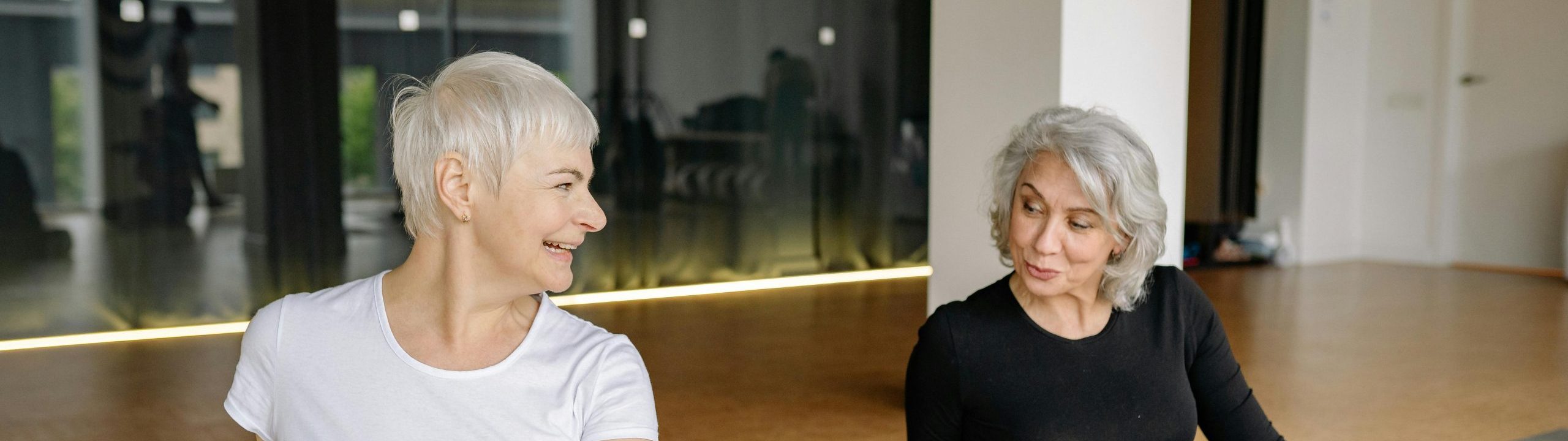 Women on yoga mats looking at each other