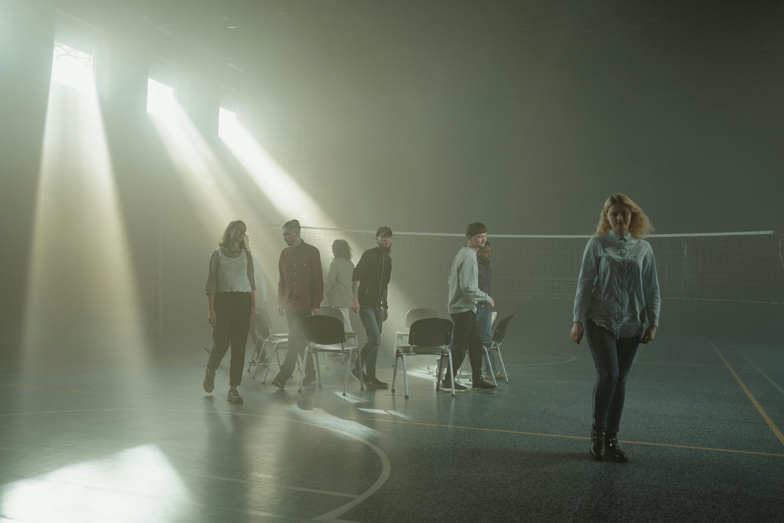 People standing around in a poorly lit gym hall